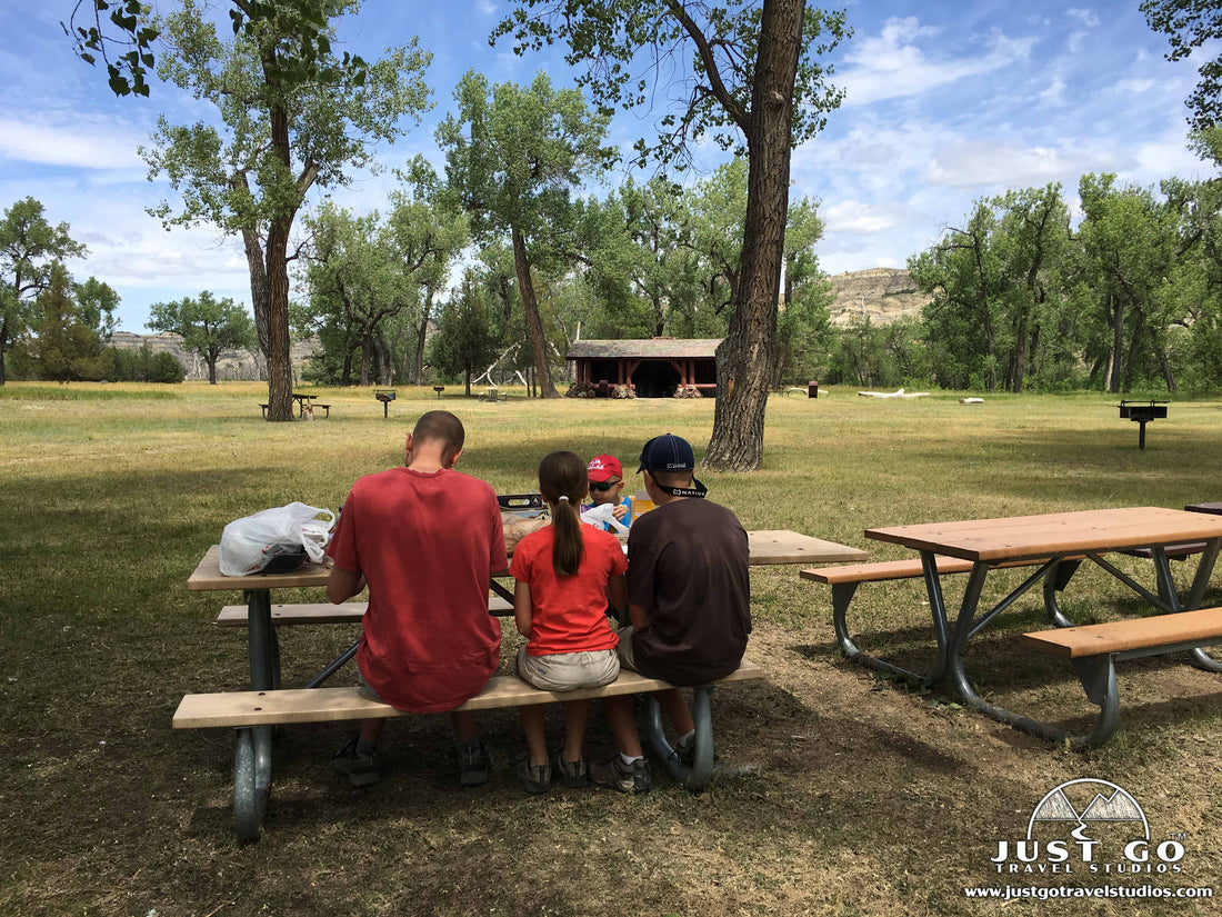 Family camping at Theodore Roosevelt National Park campground with picnic table and badlands scenery