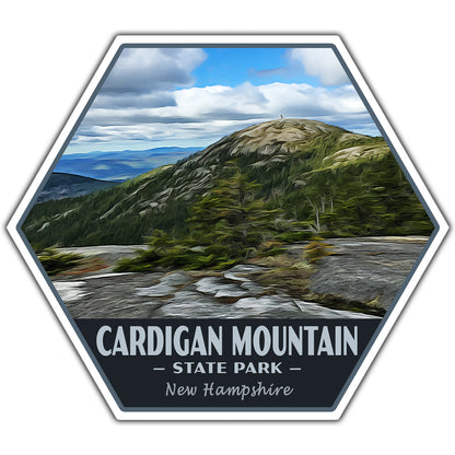 A hexagonal sticker or patch design featuring a scenic landscape of Cardigan Mountain in New Hampshire, with a rocky peak, green forest, blue sky, and the text 'CARDIGAN MOUNTAIN - STATE PARK - New Hampshire' on a dark background.