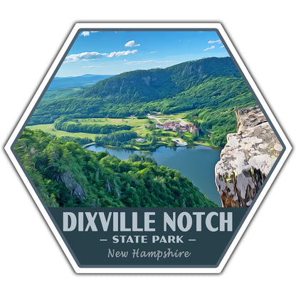A hexagonal scenic sticker or print featuring an aerial view of Dixville Notch State Park in New Hampshire, with green mountains, a lake, fields, and a rocky cliff. Text at the bottom reads “DIXVILLE NOTCH • STATE PARK • New Hampshire.